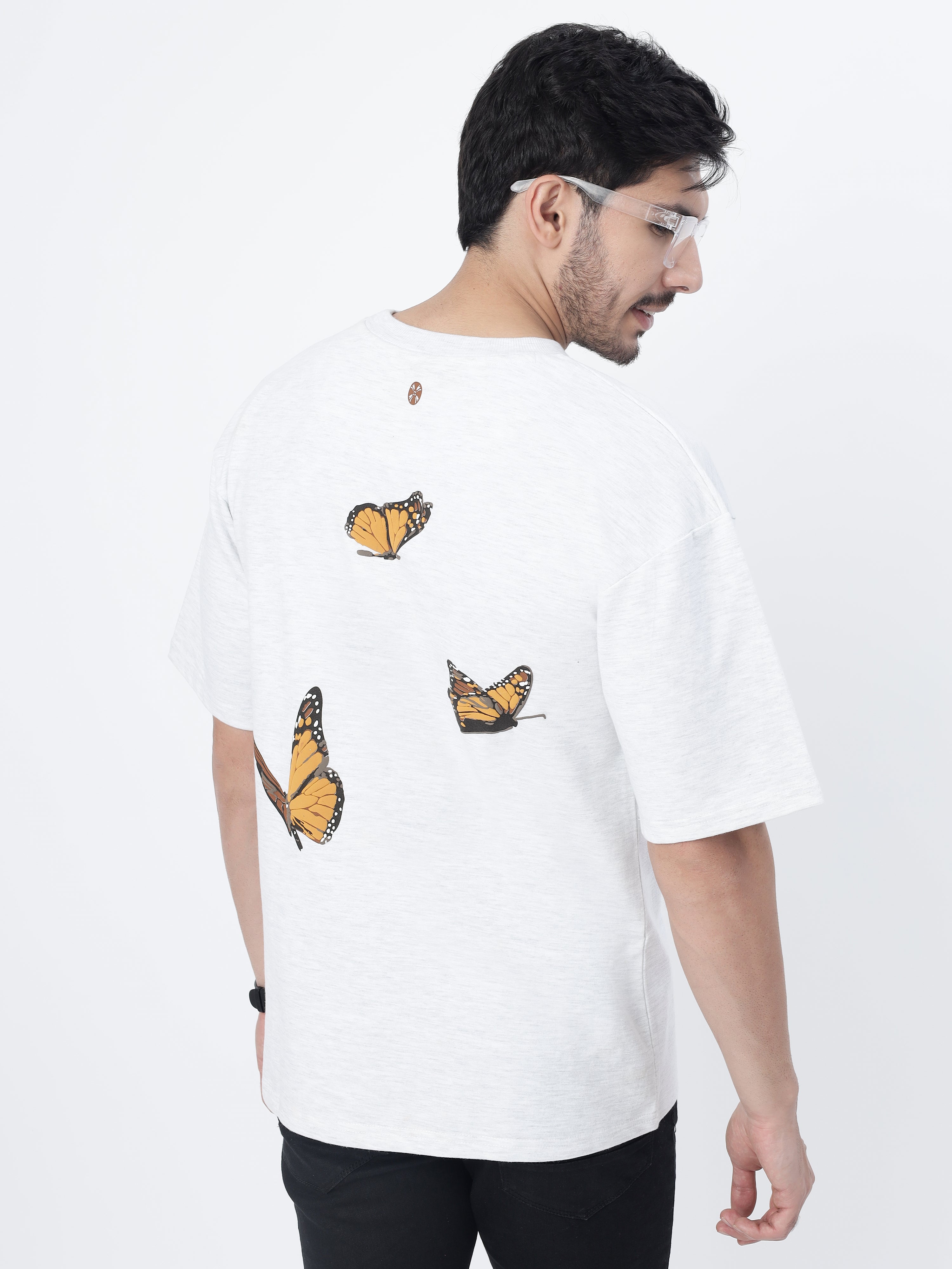 Model showcasing the back print of White orange butterflies oversized t-shirt on a white background.