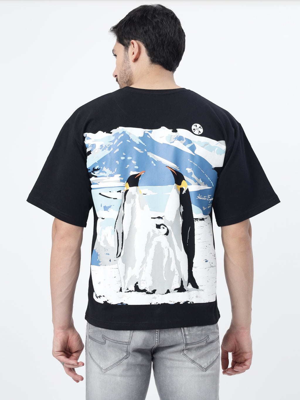 Model showcasing the back print of Black antarctic emperor oversized t-shirt, on a white background.