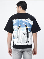 Model showcasing the back print of Black antarctic emperor oversized t-shirt, on a white background.