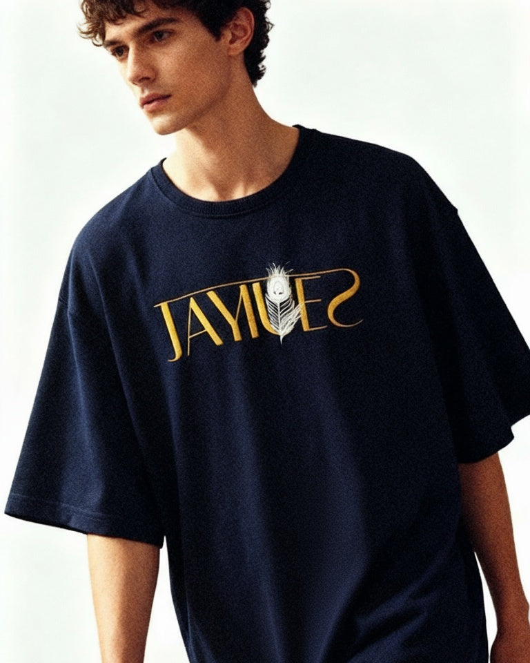Person wearing a jayhues navy peacock feather oversized t-shirt on a white background.