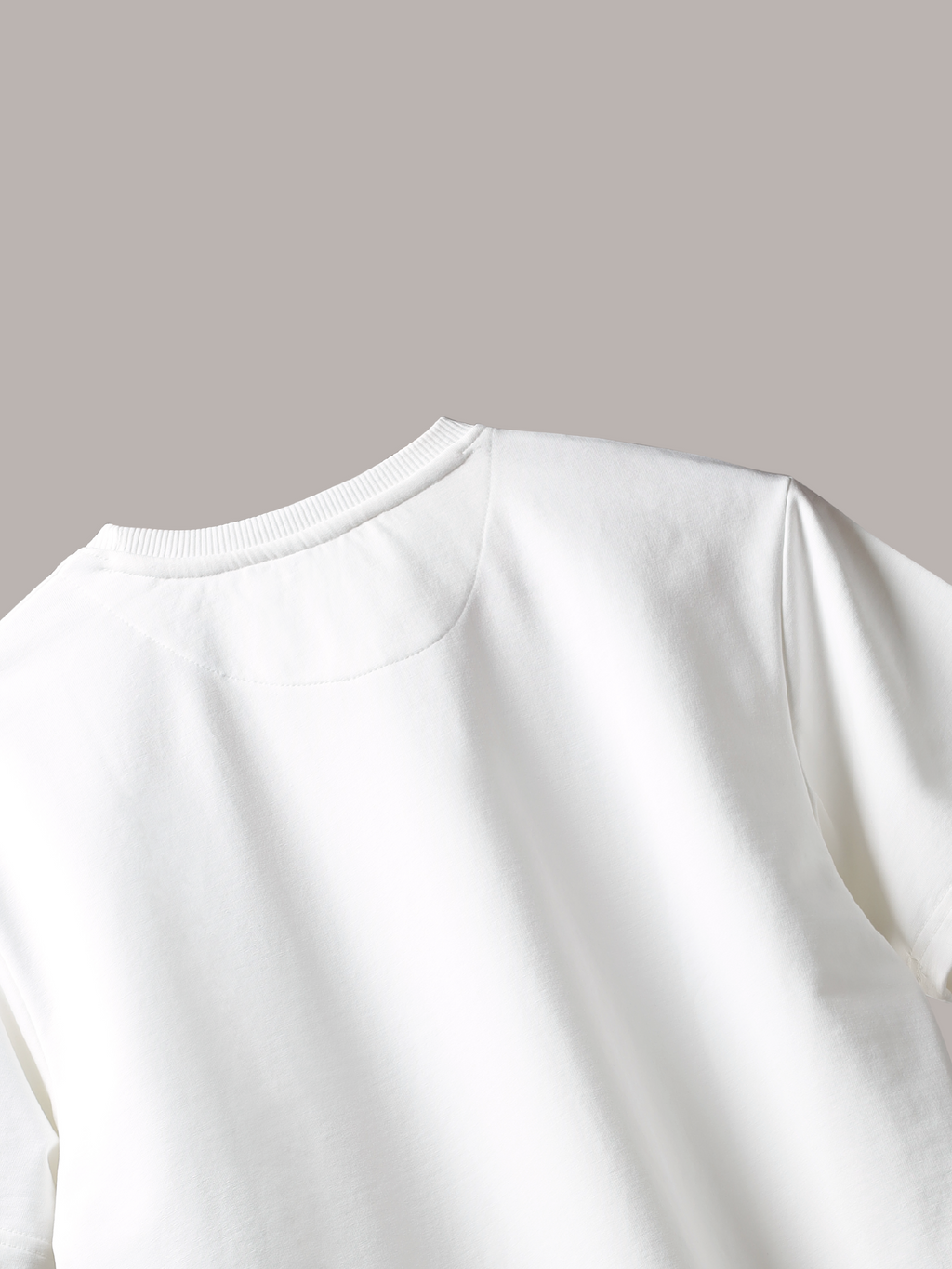 Close-up of a Jayhues White basic t-shirt on a light gray background