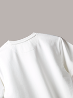 Close-up of a Jayhues White basic t-shirt on a light gray background