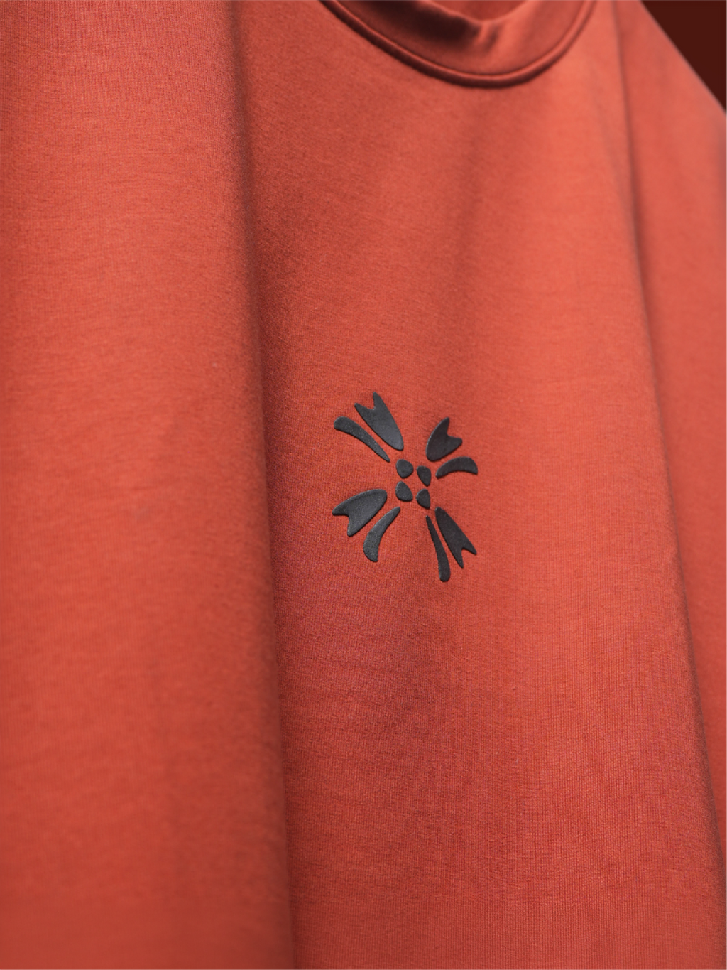 Close-up of the rust basic mark t-shirt featuring the HD printed black logo on the chest.
