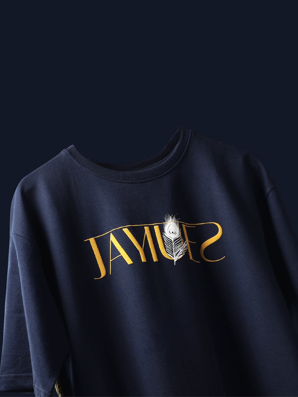 Navy peacock feather oversized t-shirt on a blue background.