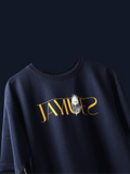 Navy peacock feather oversized t-shirt on a blue background.