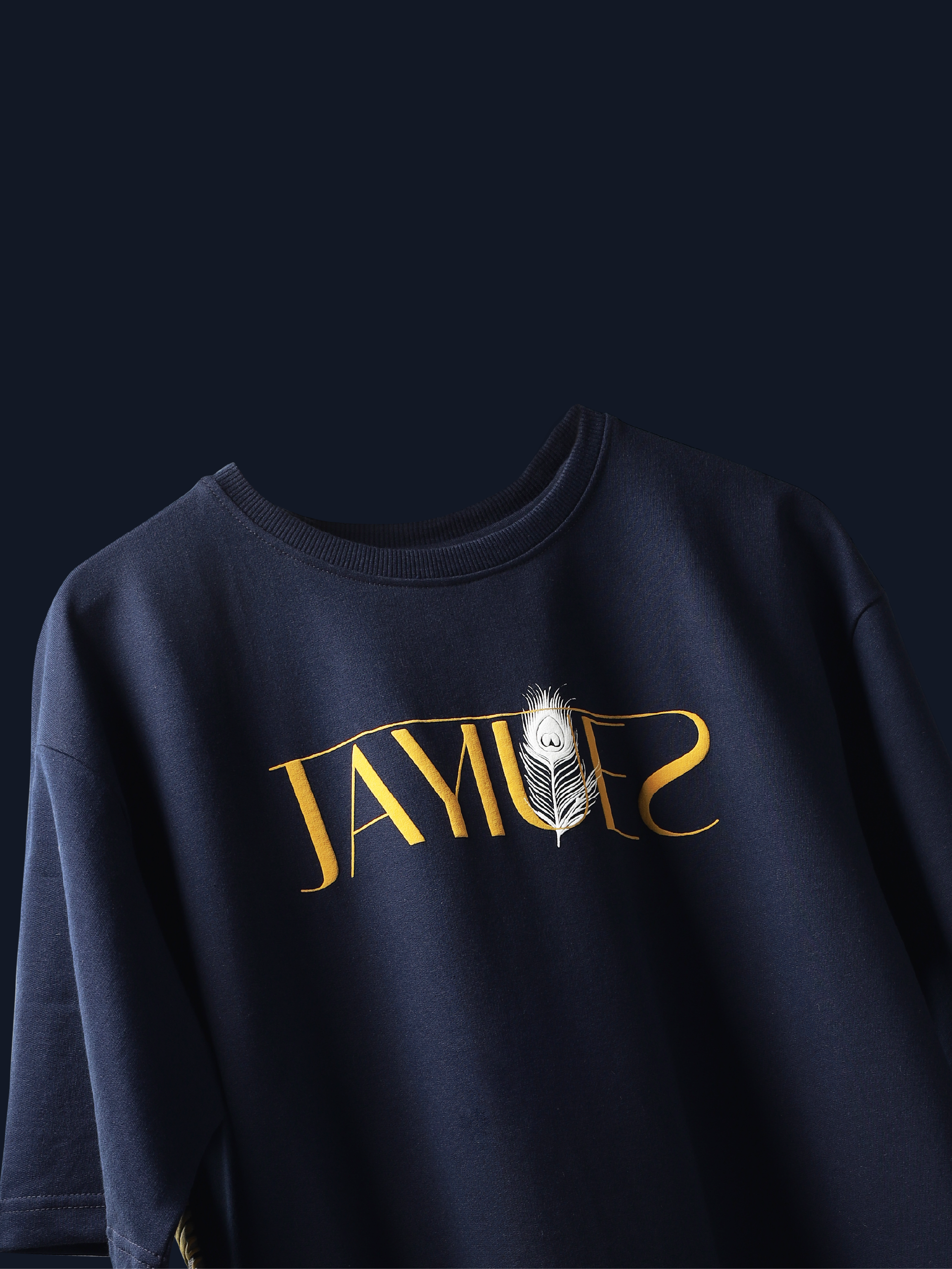 Navy peacock feather oversized t-shirt on a blue background.