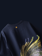 Back side of Navy peacock feather oversized t-shirt on a blue background.