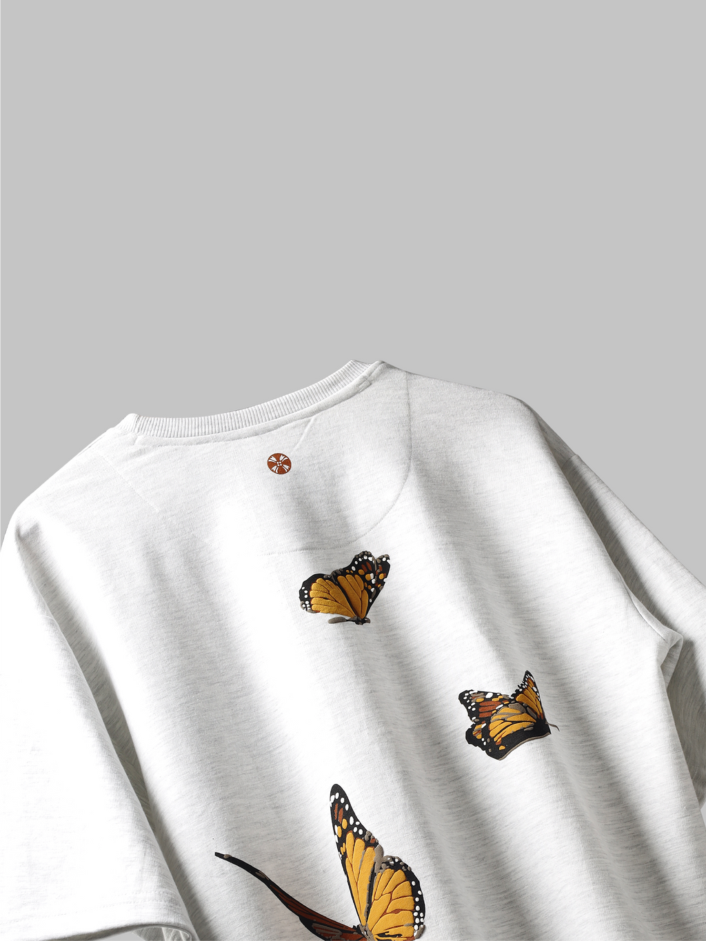 Back side of White yellow butterflies oversized t-shirt on grey background.