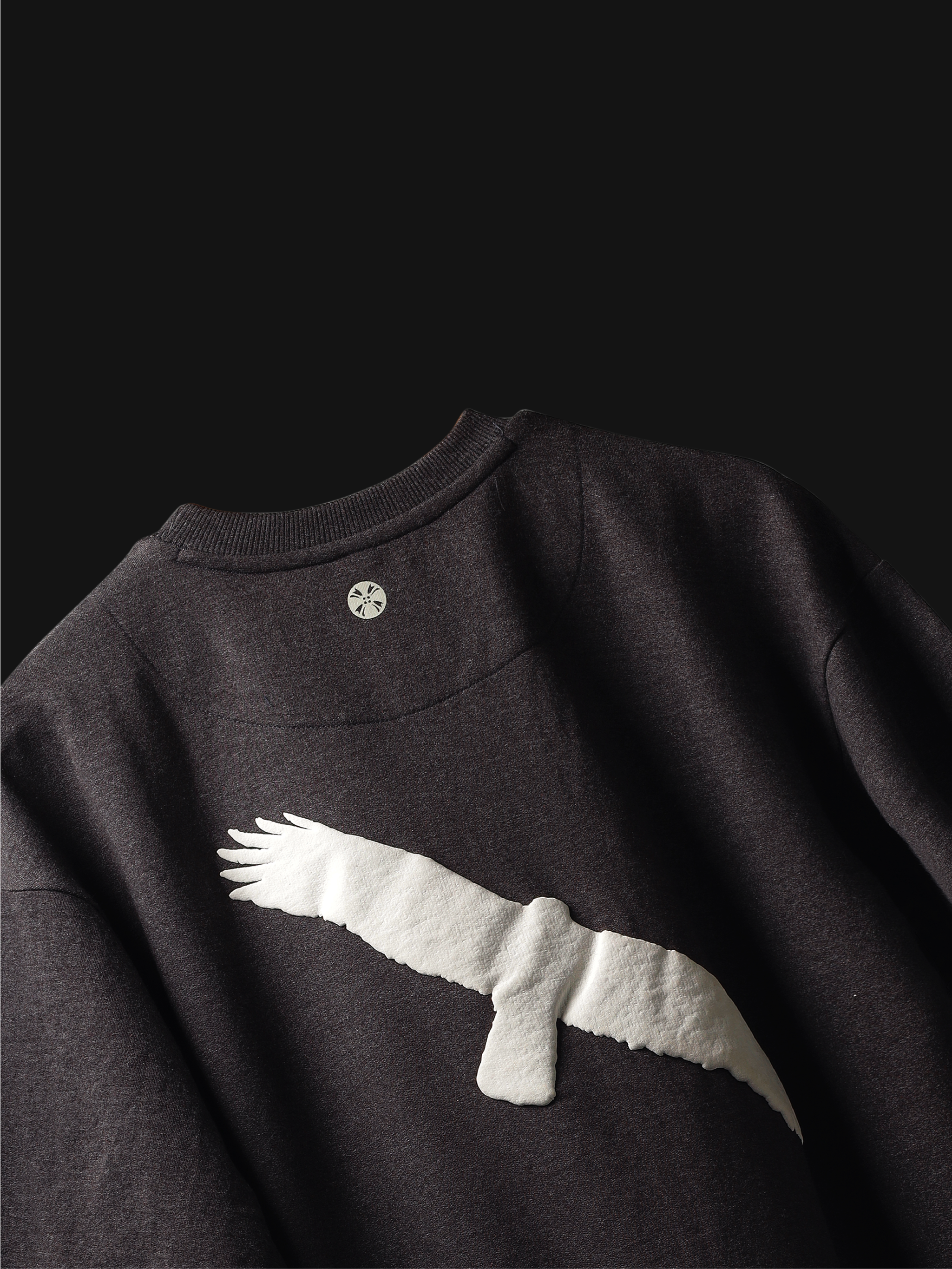 Back side of Charcoal fat eagle oversized t-shirt on a dark background.
