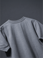 Close-up of the back of the grey basic t-shirt against a dark gray background.