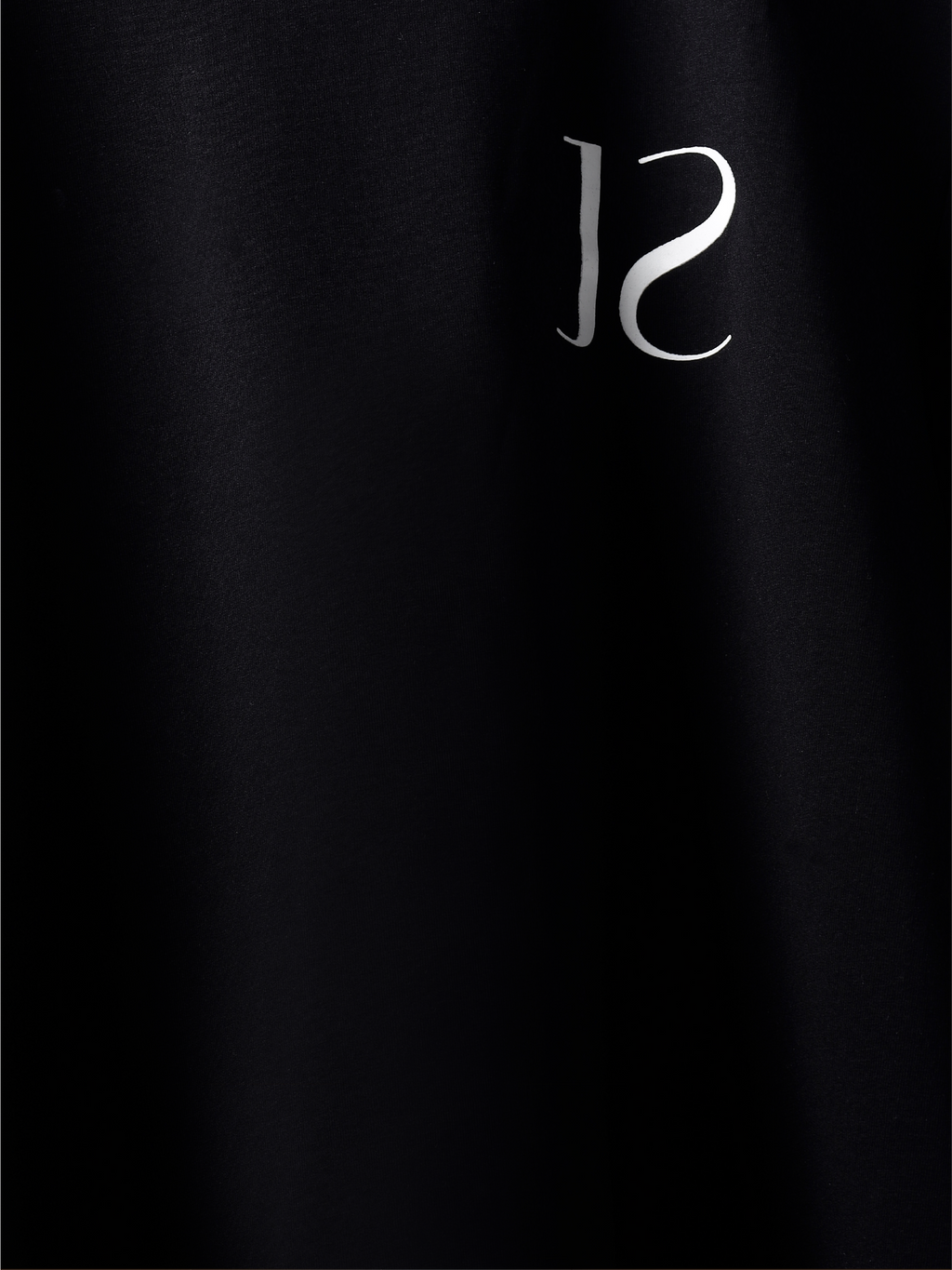 closeup of Black jayhues marque t-shirt front side.