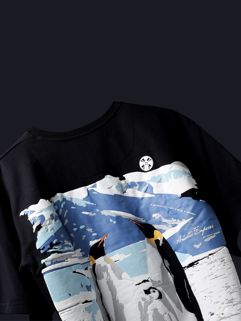 Back side of Black antarctic emperor oversized t-shirt on a dark background