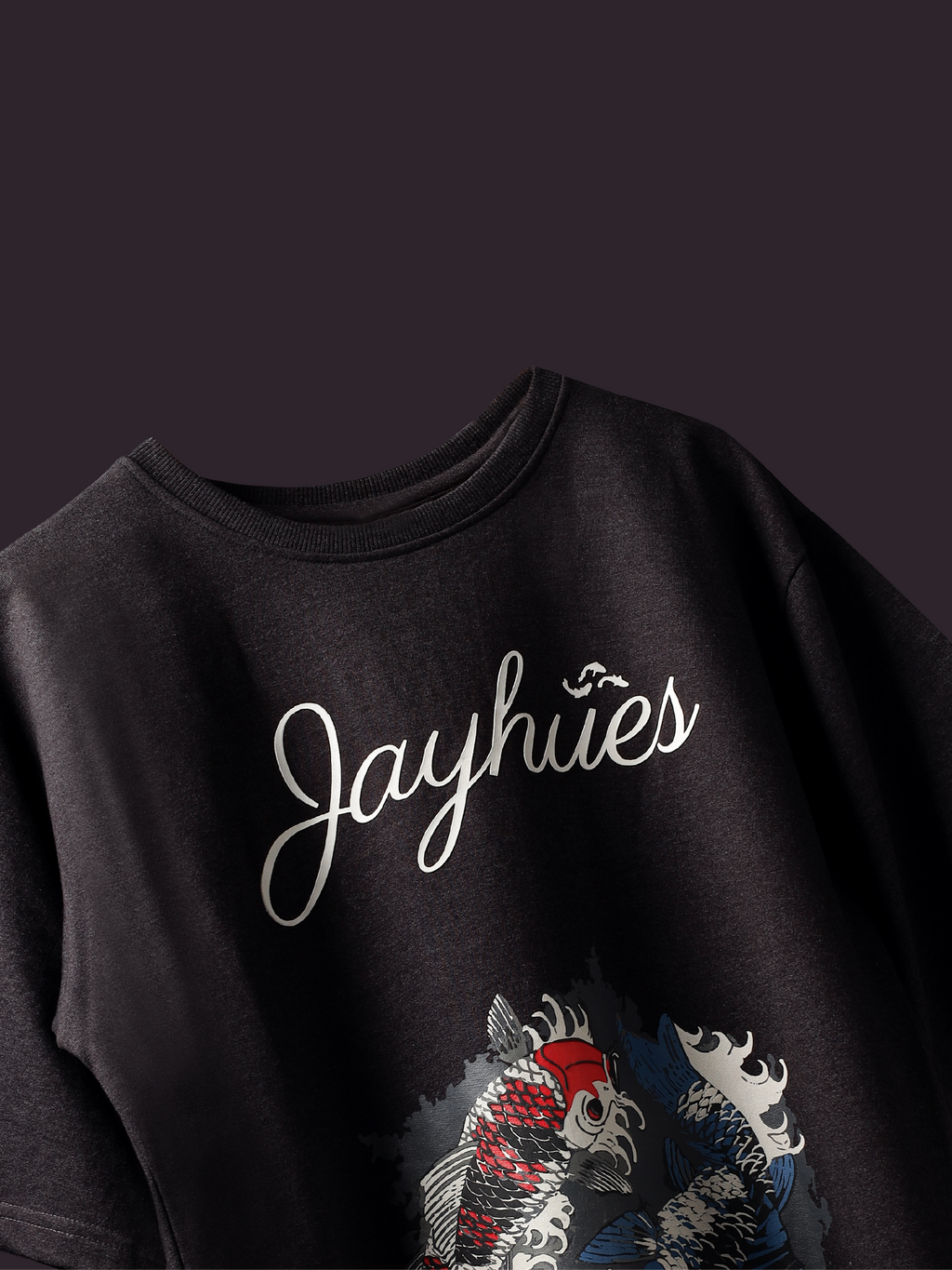 Charcoal Pisces Koi oversized t-shirt on a dark background.