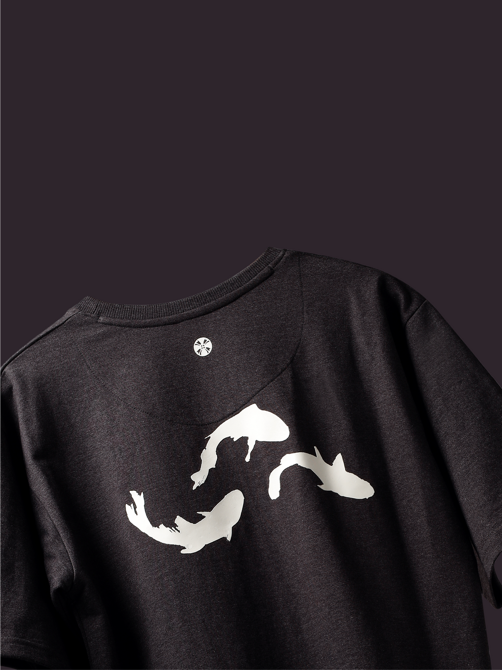 Back side of Charcoal Pisces Koi oversized t-shirt on a dark background.
