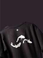 Back side of Charcoal Pisces Koi oversized t-shirt on a dark background.