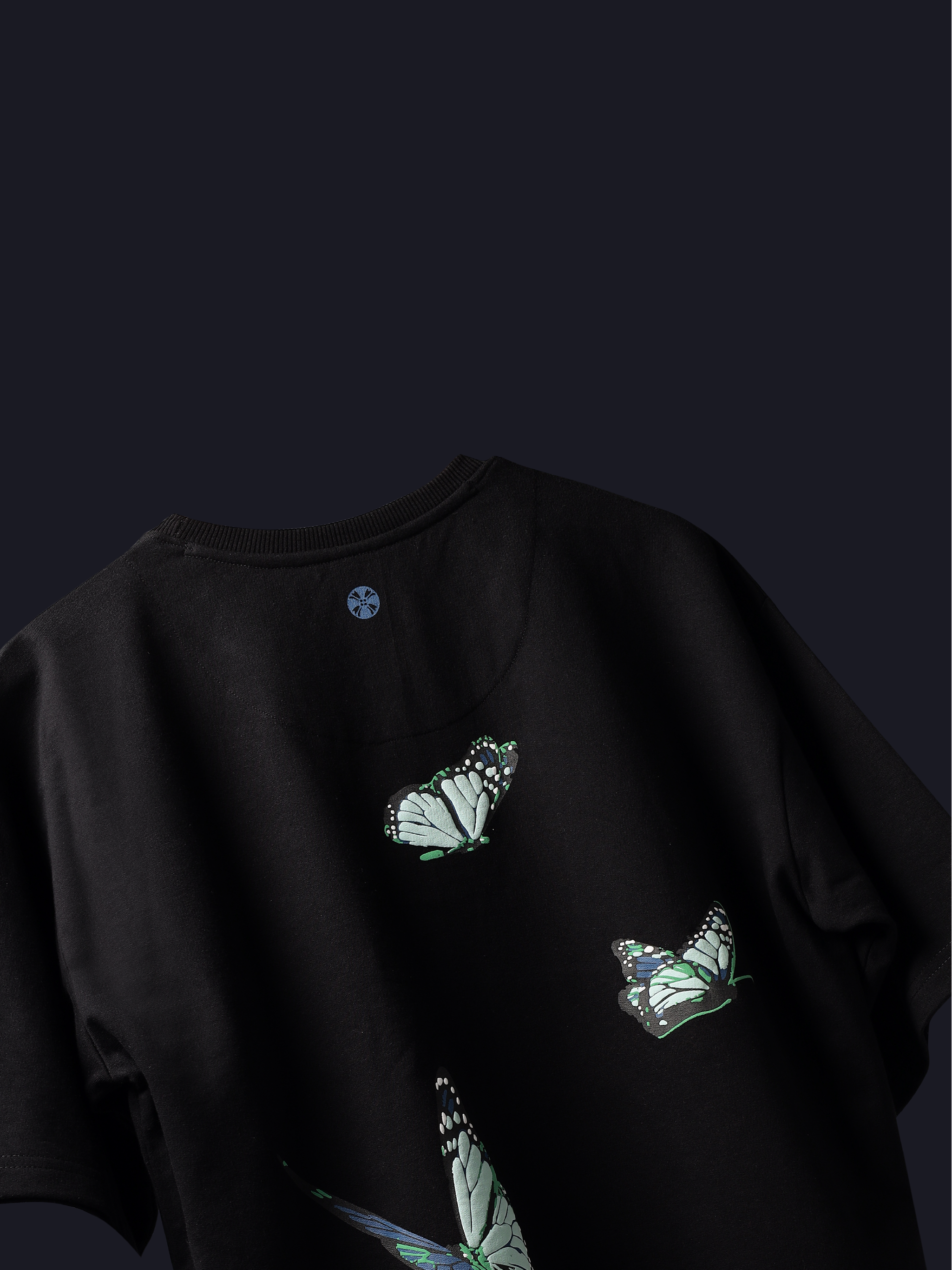 Back side of Black blue butterflies oversized t-shirt on dark background.