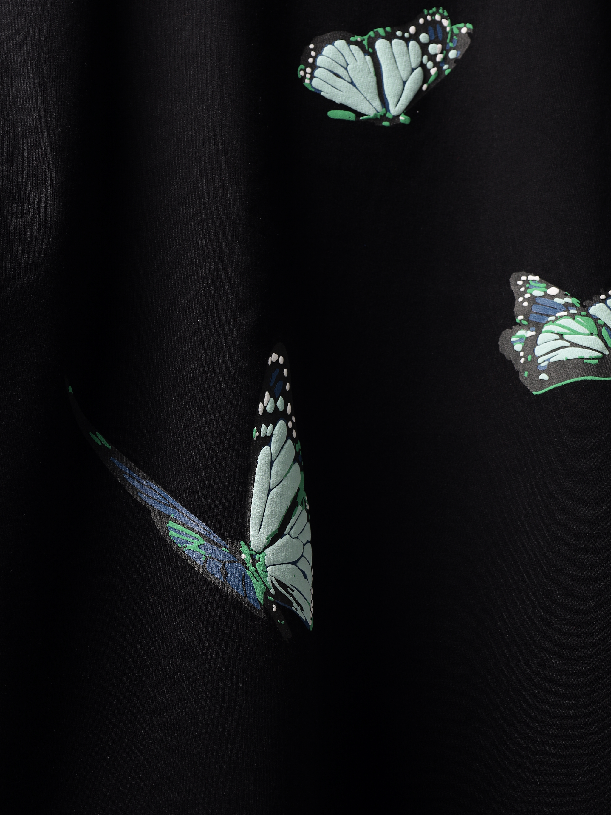Close up of Butterfly pattern on a back of Black blue butterflies oversized t-shirt.