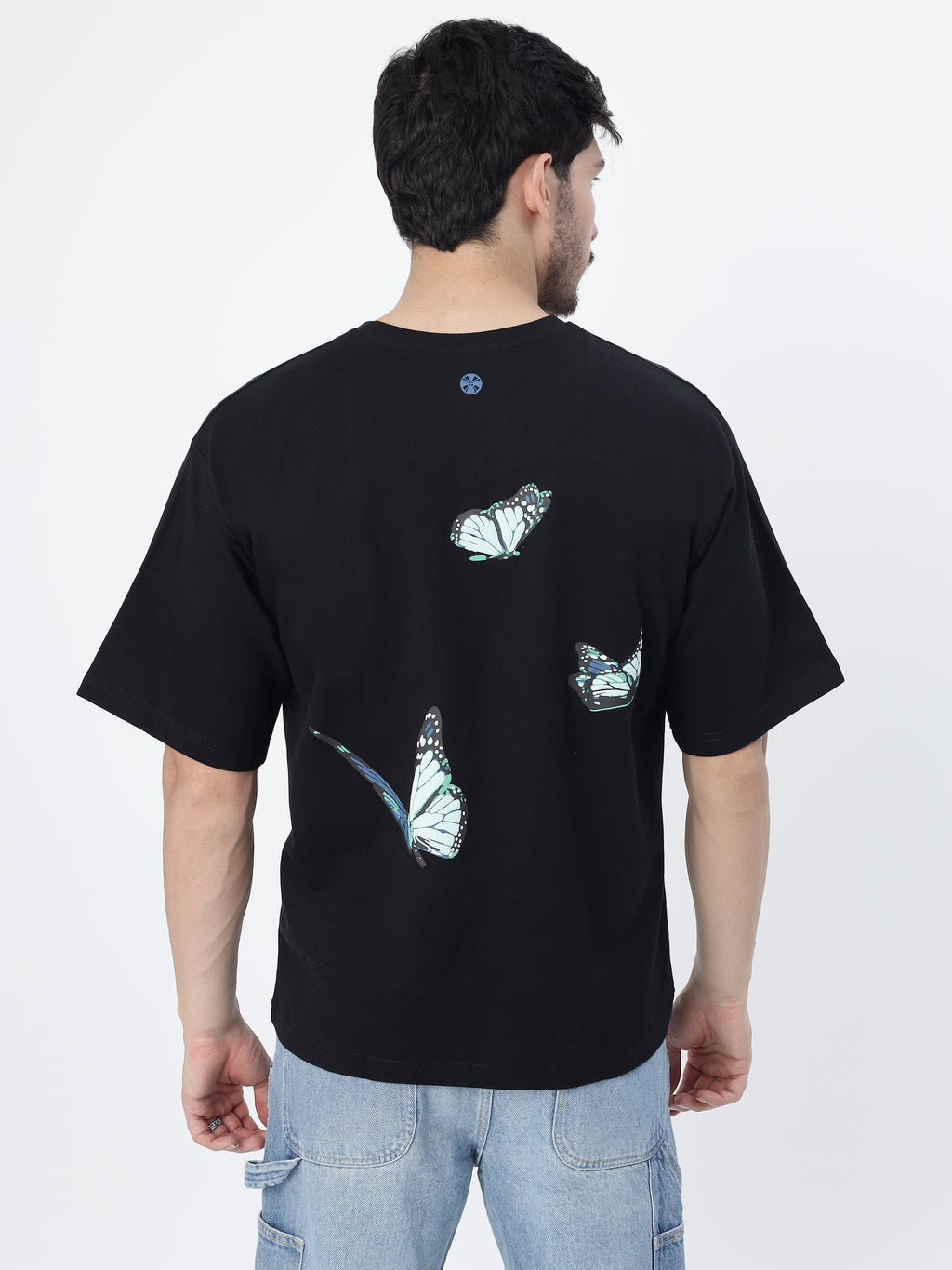 Model showcasing the back side of Black blue butterflies oversized t-shirt on a white background.