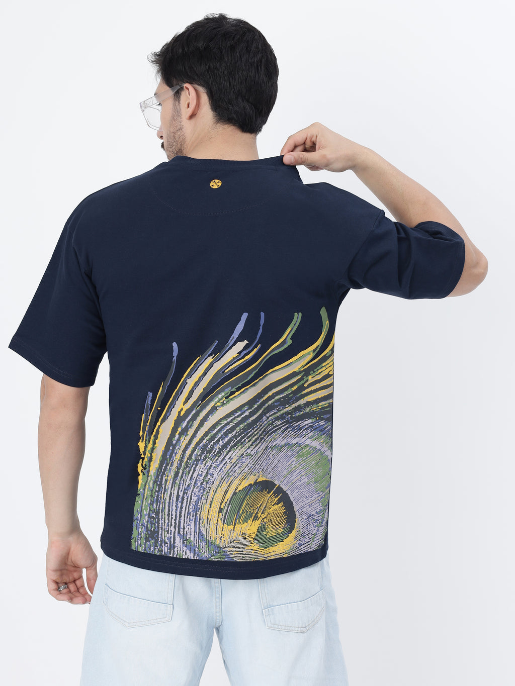 Model showcasing the back print of Navy peacock feather oversized t-shirt on a white background.