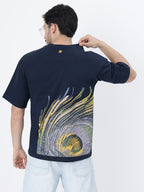 Model showcasing the back print of Navy peacock feather oversized t-shirt on a white background.